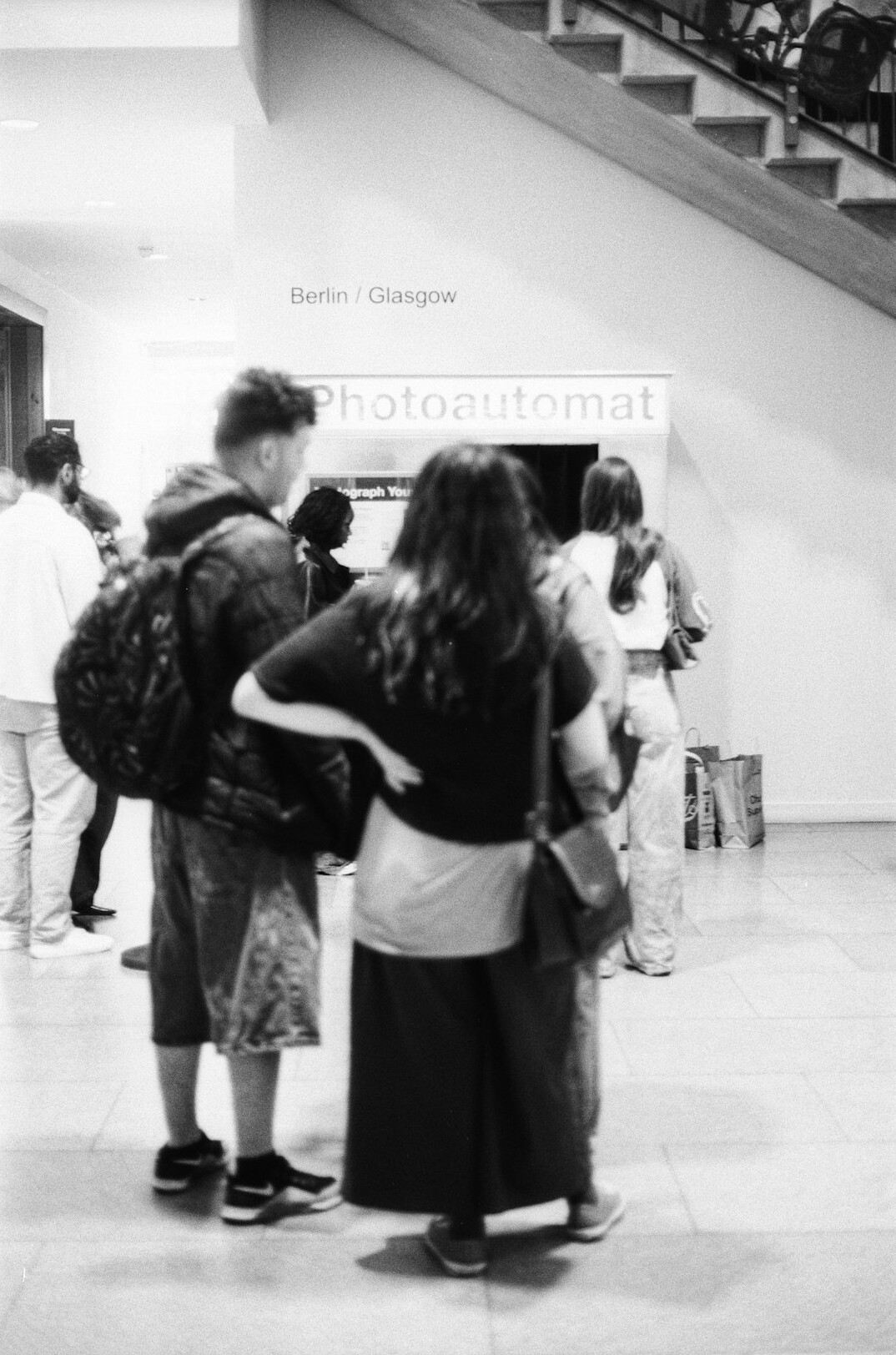 A photographer interviewing a person standing in a queue